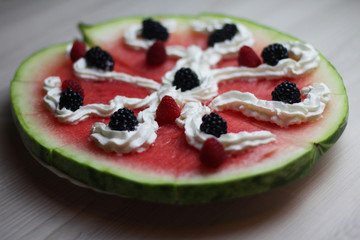 Tasty watermelon pizza with fresh berries and cream