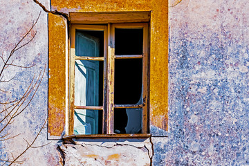 decaying old window on weathered house facade