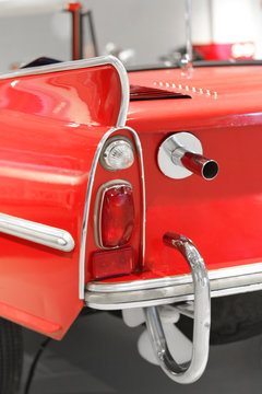 Part of red oldtimer with rear light and exhaust