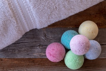 Colorful bath bombs with accessories on weathered wood.
