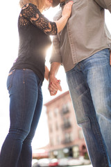 Young couple holding hands and kissing downtown