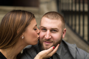 Young woman kissing fiance on cheek