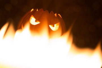 Spooky smiling halloween pumpkin in hot burning hell fire flames. The big helloween symbol has a...