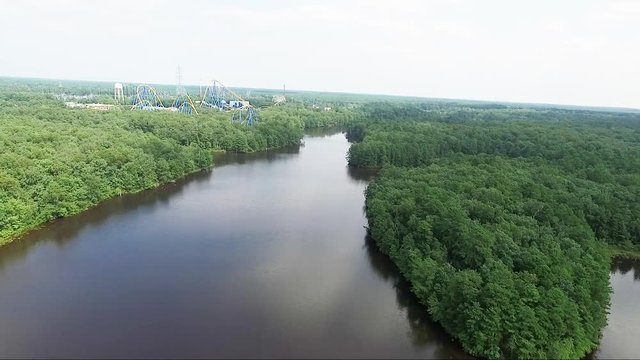 Wide aerial, rollercoasters near lake