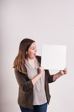 Young Female Lady Looking At Blank Square Canvas Happy Surprised Look On Her Face