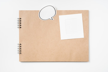 kraft notebook, photo frame and pen on white