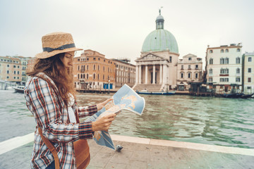 Discovery the Venice. Traveler girl looks at the map of walking, female adventure in Venice, Chiesa di San Simeone Piccolo, Italy