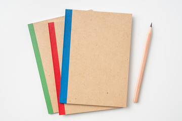 3 kraft notebook and pen on white background