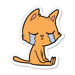 sticker of a crying cartoon cat sitting