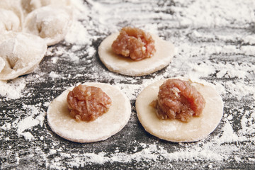 cooking dumplings on mug of dough is ball of minced meat close-up