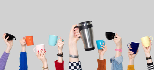 Many different hands holding coffee cups