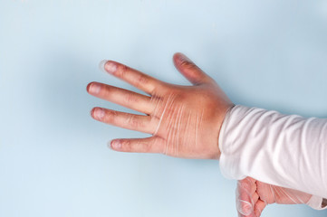 Doctor puts on medical nitrile white gloves on a blue background.