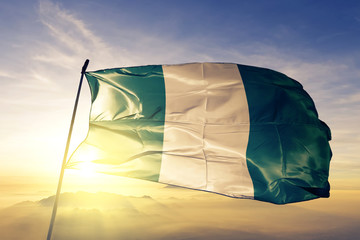Nigeria flag waving on the top sunrise mist fog