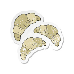 retro distressed sticker of a cartoon croissants