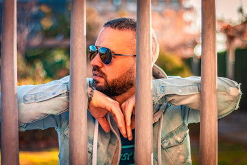 Obraz premium Portrait of young posing with sunglass in casual and modern clothing in a park