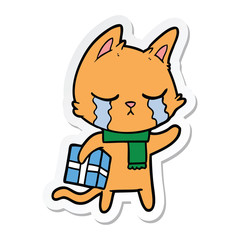 sticker of a crying cartoon cat holding christmas present