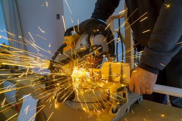 Sparks while grinding iron, metal sawing, worker man
