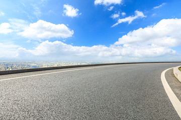 Asphalt highway passing above modern city