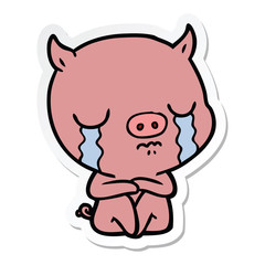 sticker of a cartoon sitting pig crying