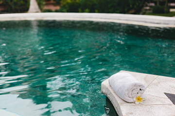Towel and flower in luxury spa jacuzzi pool