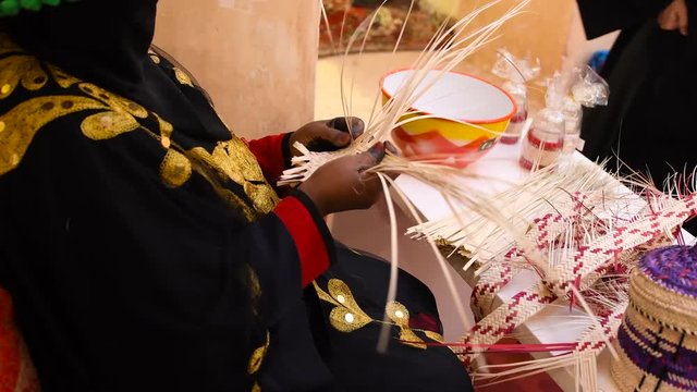 Woman from Saudi Arabia doing handcraft straw.