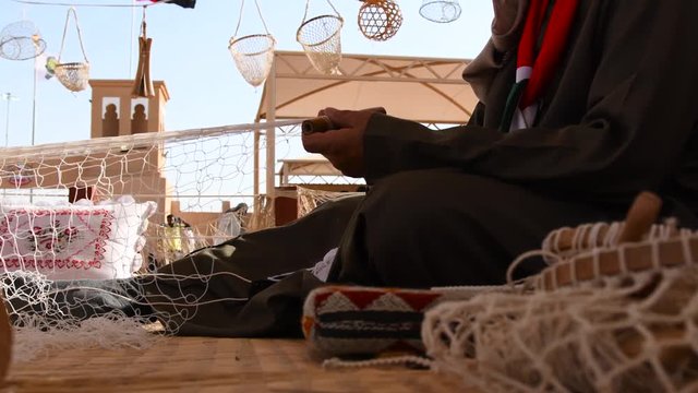 Man from Saudi Arabia doing handcraft work. He is preparing a fishnet.