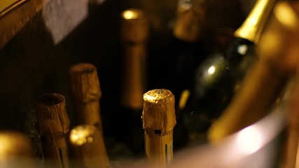 Gold champagne bottles in a metal cooler filled with ice - Powered by Adobe