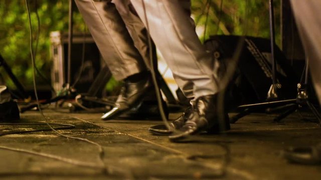 Low angle shot of a band members feet dancing together in synchronisation during a performance