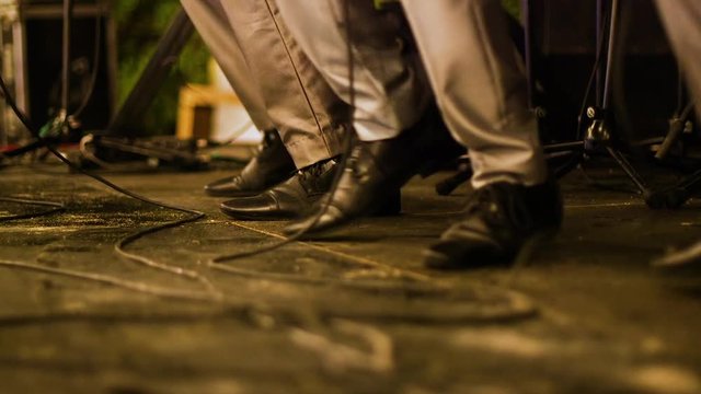 Low angle shot of a band performing and dancing on stage in perfect synchronisation