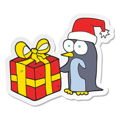sticker of a cartoon christmas penguin with present