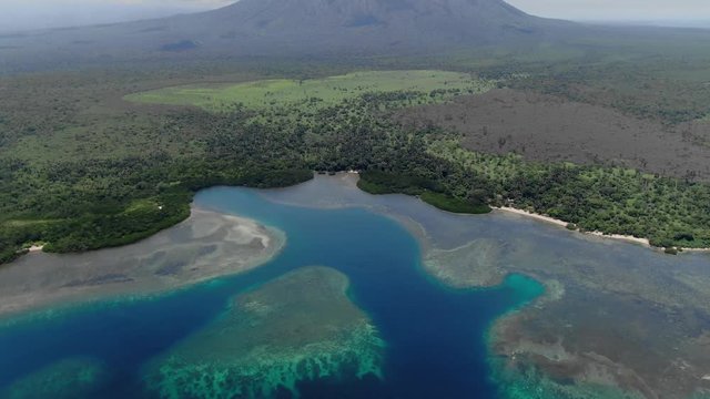 Aerial drone shot with a tilt reveal of Bama Beach, Baluran National Park and Mount Baluran in East Java Indonesia