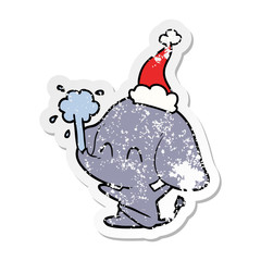cute distressed sticker cartoon of a elephant spouting water wearing santa hat
