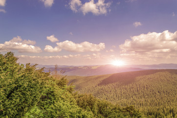 warm sunrise scene on the mountain. Twilight sky with clouds.