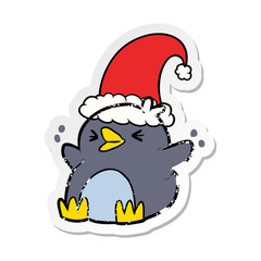distressed sticker of a cartoon penguin wearing christmas hat