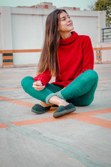  beautiful woman with red jacket and red pacifier sitting in a parking lot