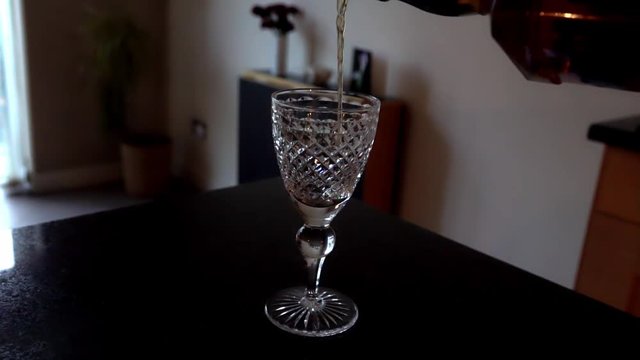 Whisky being poured into a crystal glass, in four times slow motion.