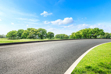 Asphalt road and green forest landscape in summer season