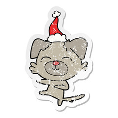 distressed sticker cartoon of a dog kicking wearing santa hat