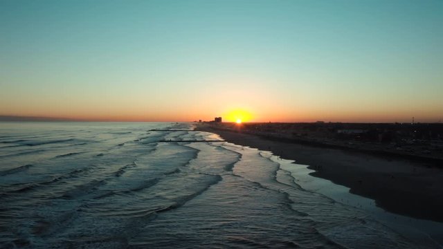 Beach shore view with a distant sunset.