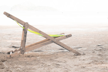 Fototapeta premium Wooden chaise lounge on a soft white background on beach