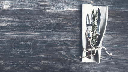 Simple laconic design cutlery on linen napkin on rustic wooden table. Concept of natural organic eating.