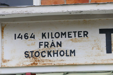 Kiruna, Sweden  A distance sign (1464 kilometers) on an old train station in Torneträsk.