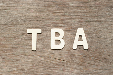 Alphabet letter in word TBA (abbreviation of to be announced) on wood background
