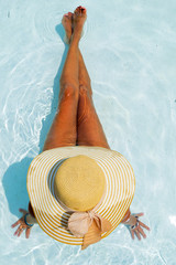 Woman relaxing at the swimming pool at the luxury resort
