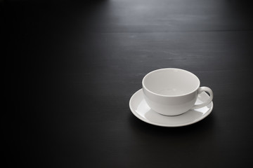 White ceramic coffee mugs over a black wooden table.
