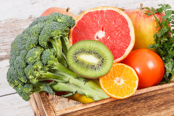 Fruits with vegetables in box as food containing minerals and vitamins, diet and slimming concept