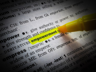 A close up of the word:  empowerment,in a dictionary, highlighted in yellow and showing part of its definition.