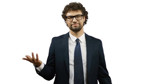 Good looking Caucasian businessman in glasses, suit and tie standing on the white wall screen and doing gesture so-so or fifty-fifty with a hand.