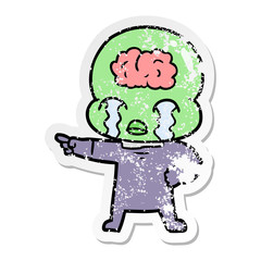 distressed sticker of a cartoon big brain alien crying and pointing