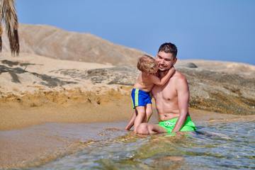 Fototapeta premium Toddler boy on beach with father